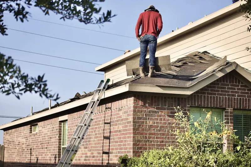 Professional roofer working on a residential roof in Muddy Ford